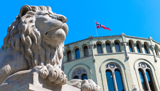 Bilde av en steinløve foran Stortinget.