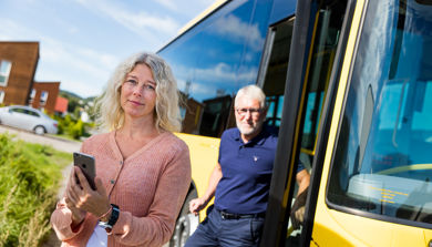 En mann og en kvinne som står ved siden av en buss