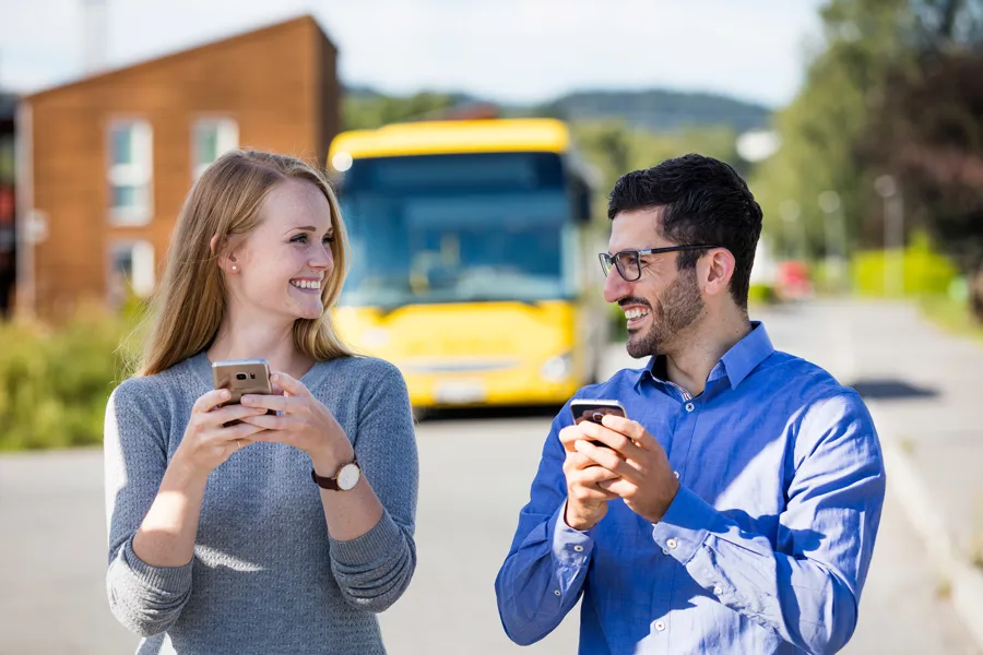 En mann og en kvinne som ser på en mobiltelefon