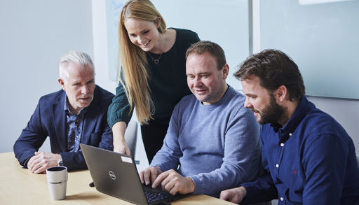A group of people looking at a laptop
