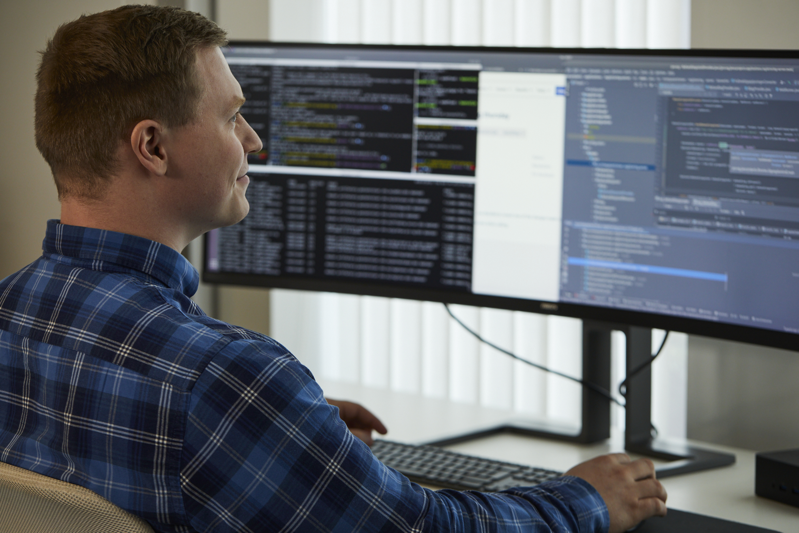 A man sitting at a desk looking at a computer screen