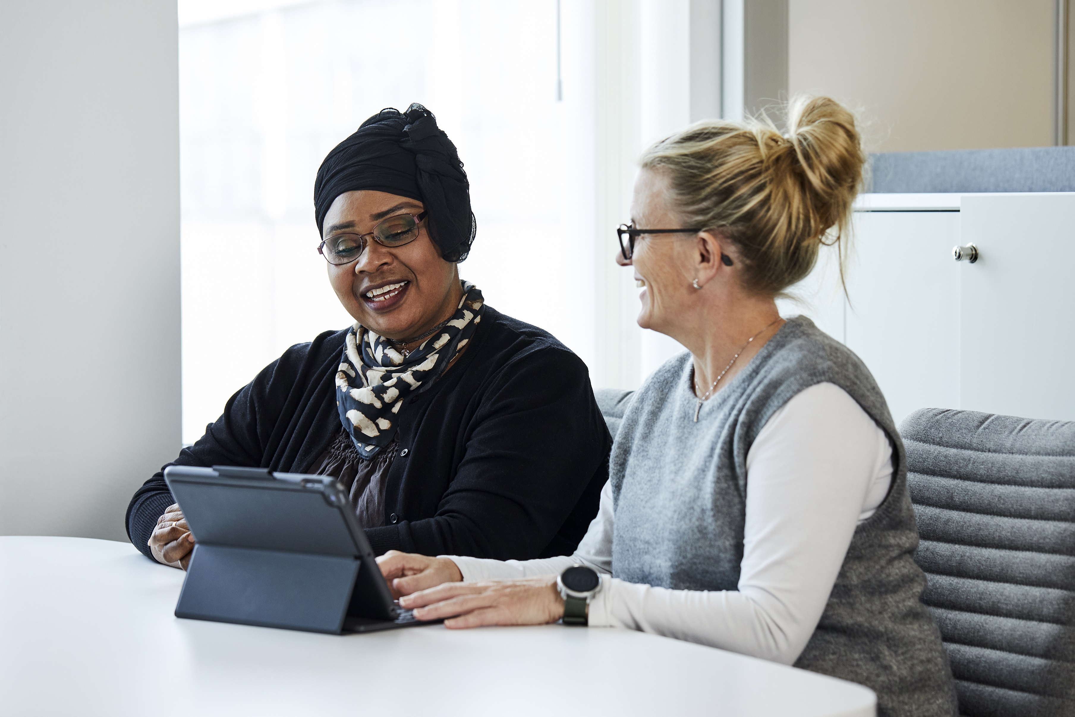 A woman showing another woman something on the laptop