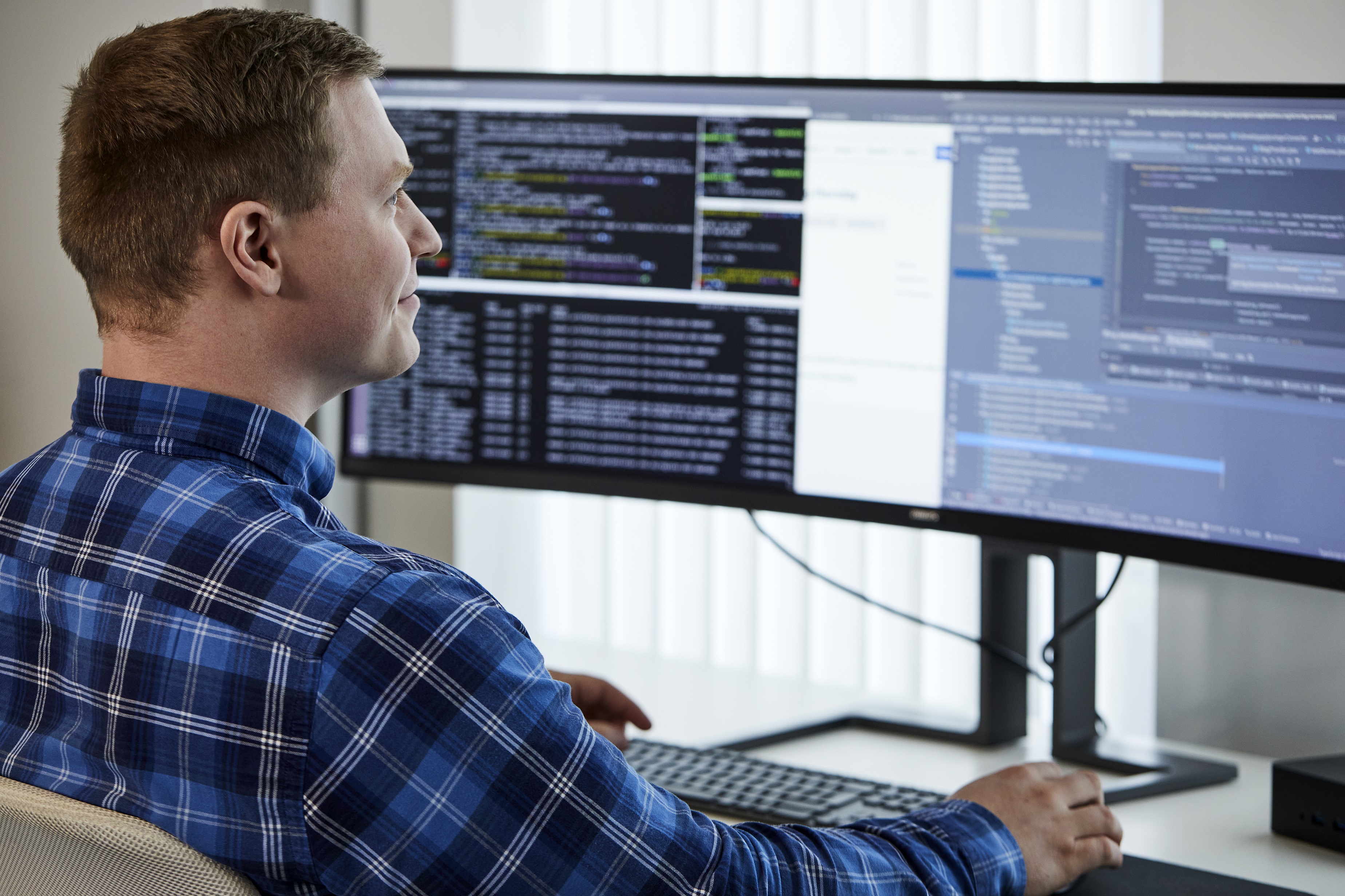 A man sitting at a desk looking at a computer screen
