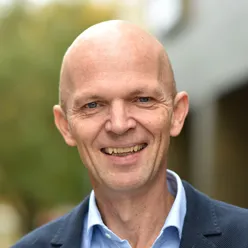 En mann som smiler til kameraet