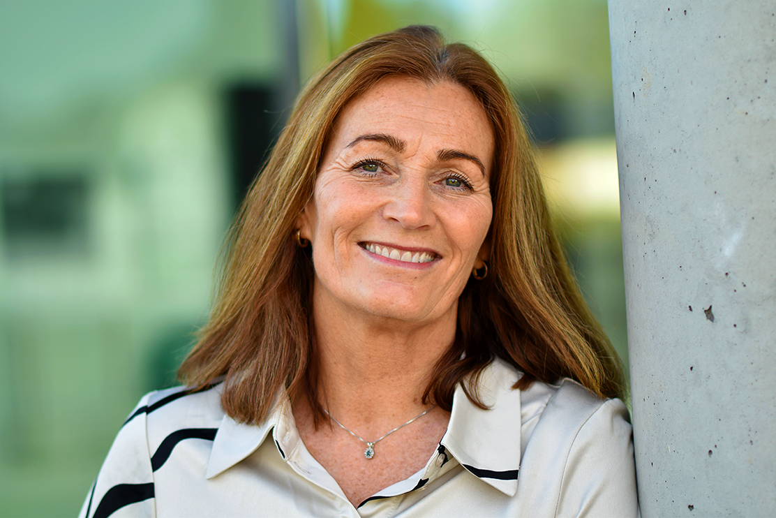 En kvinne som smiler til kameraet