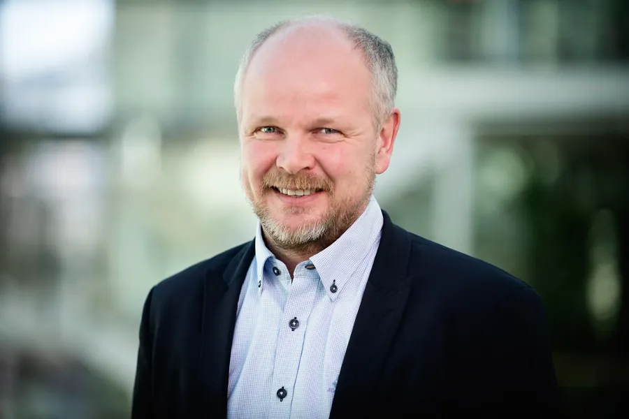En mann som smiler til kameraet