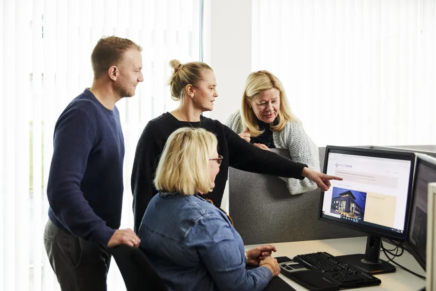 En gruppe mennesker som ser på en dataskjerm